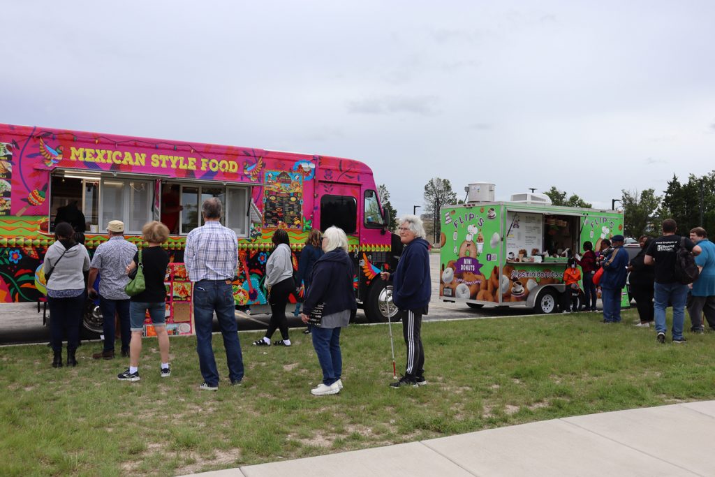 Photograph of a crowd of people waiting in line at Romero's Taco Truck and Flip's Mini Donuts.